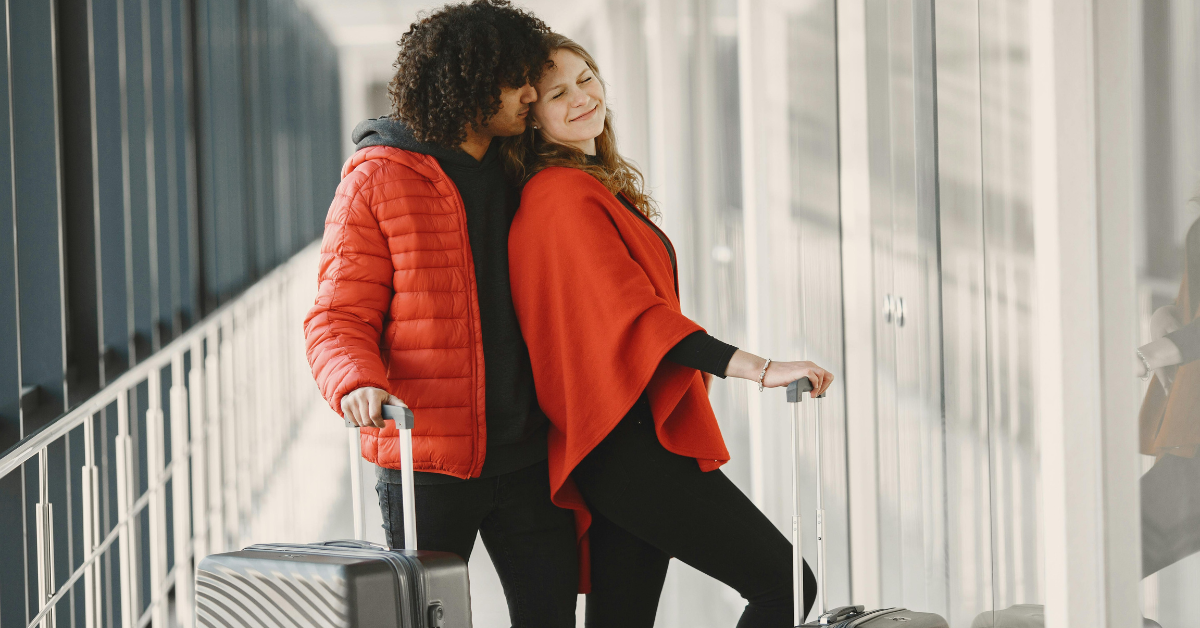 Traveler wearing a comfortable casual outfit walking through an airport terminal with a suitcase during a travel day