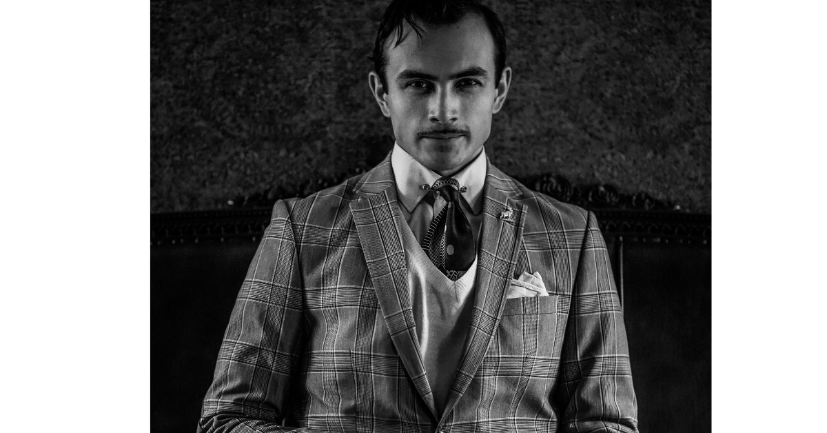 Man wearing a tailored 1920s inspired plaid three piece suit with vest and tie