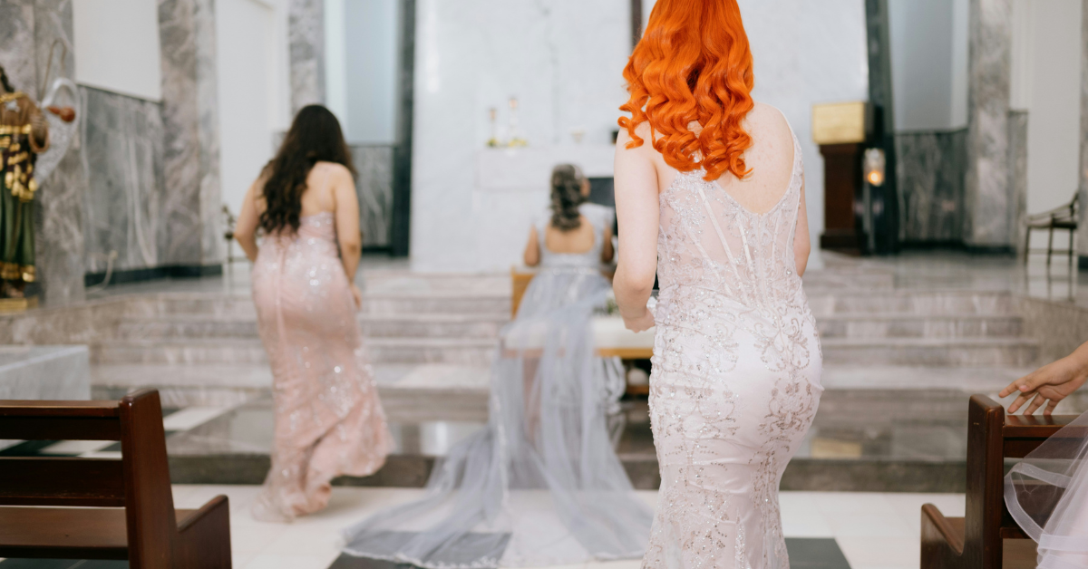 Elegant fall wedding guest dresses inside a formal church ceremony setting